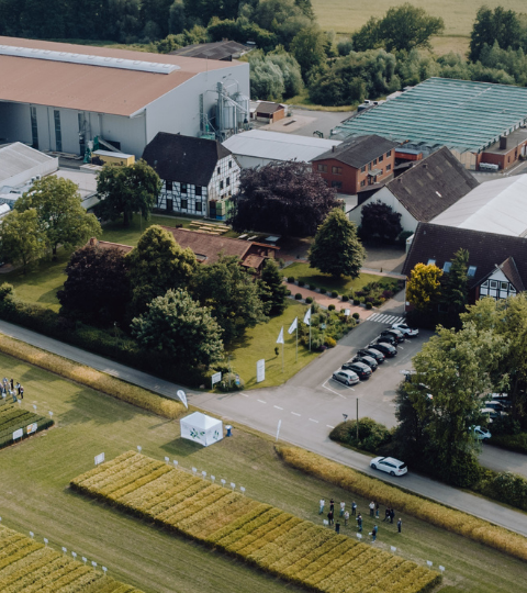 Syngenta Seeds auf der Domäne Biemsen Luftaufnahme eines Industriegebäudes mit Parkplatz und Solarpanels auf dem Dach