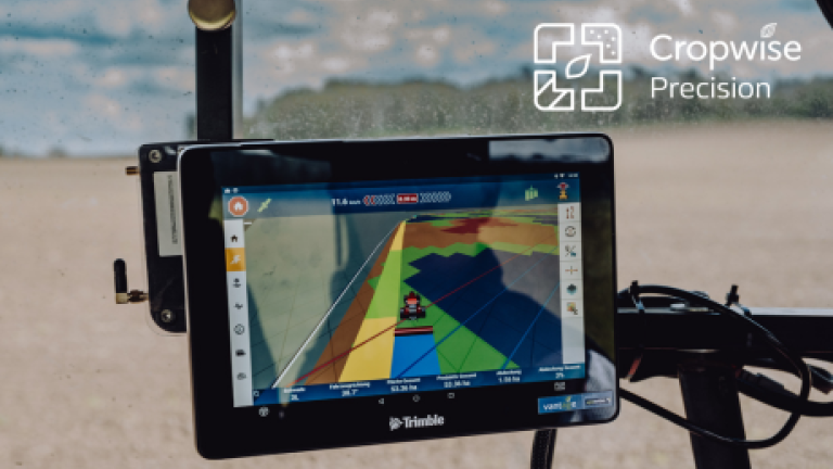 Tablet mit Precision-Software zeigt Feldkarte auf Traktor, Acker im Hintergrund
